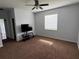 A living room features carpet flooring, a ceiling fan, and natural light at 10766 Standing Stone Dr, Wimauma, FL 33598
