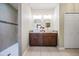 Bright bathroom featuring double vanity, modern sinks, attractive mirrors, and a stylishly tiled shower at 12745 Moorish Pl, Spring Hill, FL 34610