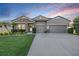 Beautiful single-story home with stone accents, a three-car garage, and landscaped front yard at 12745 Moorish Pl, Spring Hill, FL 34610