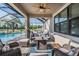 Covered lanai includes ample seating around a gas fire pit overlooking the pool and water at 12745 Moorish Pl, Spring Hill, FL 34610