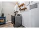 Efficient laundry room with modern machines, wood-look floors, and decorative shelving at 12745 Moorish Pl, Spring Hill, FL 34610