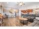 Open concept living room with dining area and kitchen, featuring hardwood floors and modern furnishings at 12745 Moorish Pl, Spring Hill, FL 34610