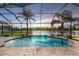 Private screened-in pool with a waterfall feature and beautiful lake view at 12745 Moorish Pl, Spring Hill, FL 34610