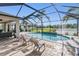 Enclosed pool and patio area featuring multiple seating options and lake views at 12745 Moorish Pl, Spring Hill, FL 34610