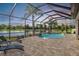 Screened in lanai with a pool and waterfall feature overlooks a serene lake view at 12745 Moorish Pl, Spring Hill, FL 34610