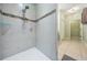 Modern bathroom featuring a stylishly tiled shower with sleek fixtures and a convenient grab bar at 12745 Moorish Pl, Spring Hill, FL 34610