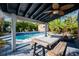 Covered outdoor dining area overlooking the refreshing pool and tropical backyard at 1304 Withlacoochee St, Safety Harbor, FL 34695