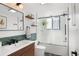 Bright bathroom featuring a modern vanity, floating shelves, and a glass-enclosed shower with subway tile at 1304 Withlacoochee St, Safety Harbor, FL 34695