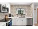 Modern kitchen featuring white cabinets, stainless steel appliances, and a decorative backsplash at 1304 Withlacoochee St, Safety Harbor, FL 34695