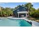 Back of home shows the pool, covered porch, and backyard with lounge chairs at 1304 Withlacoochee St, Safety Harbor, FL 34695