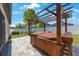Backyard with a wooden pergola covered hot tub and brick paver patio at 13213 Haystack Ct, Riverview, FL 33579