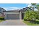 Charming one-story home featuring a two-car garage, stone accents, and well-maintained landscaping at 13213 Haystack Ct, Riverview, FL 33579