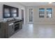 Living room featuring modern entertainment center and tile floors with a view of the lanai at 13213 Haystack Ct, Riverview, FL 33579