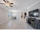 Spacious living room featuring tile floors, a ceiling fan, and an entertainment center at 13213 Haystack Ct, Riverview, FL 33579