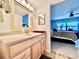 Well-lit bathroom with a sink vanity and an adjoining view into the bedroom at 1332 Pasadena S Ave # 208, South Pasadena, FL 33707
