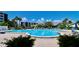 Large community pool surrounded by lush greenery, lounge chairs, and umbrellas at 1332 Pasadena S Ave # 208, South Pasadena, FL 33707