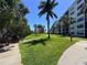 Well maintained grounds lead to a building on a bright sunny day with blue skies at 1332 Pasadena S Ave # 208, South Pasadena, FL 33707