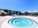 Inviting hot tub with community buildings in the background surrounded by lounge chairs and umbrellas at 1332 Pasadena S Ave # 208, South Pasadena, FL 33707