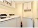 Bright laundry room featuring modern washer and dryer with storage cabinets at 1332 Pasadena S Ave # 208, South Pasadena, FL 33707