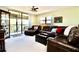 Spacious living room with a leather sofa, balcony, ceiling fan, and bright natural light at 1332 Pasadena S Ave # 208, South Pasadena, FL 33707