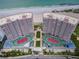 Stunning aerial view of beachfront condo buildings with private tennis courts and beautifully landscaped grounds at 1340 Gulf Blvd # 16A, Clearwater Beach, FL 33767