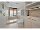Bright bathroom featuring a walk-in shower with glass door, toilet, and decorative shelving at 1340 Gulf Blvd # 16A, Clearwater Beach, FL 33767