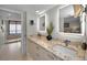 Modern bathroom with double sink vanity, granite countertop, and illuminated mirrors, leading to walk-in shower at 1340 Gulf Blvd # 16A, Clearwater Beach, FL 33767