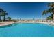 Sparkling blue pool with beach view, surrounded by lounge chairs and palm trees at 1340 Gulf Blvd # 16A, Clearwater Beach, FL 33767