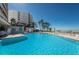 Inviting outdoor pool with palm trees and a glimpse of the ocean at 1340 Gulf Blvd # 16A, Clearwater Beach, FL 33767