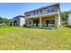 A lush, spacious backyard features a manicured lawn and covered patio, perfect for outdoor enjoyment at 14137 Wake Robin Dr, Brooksville, FL 34604