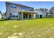 A well-maintained backyard with a spacious lawn and covered patio area at 14137 Wake Robin Dr, Brooksville, FL 34604