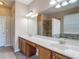 Spacious bathroom featuring a large vanity with dual sinks, tile flooring, and a walk-in shower at 14137 Wake Robin Dr, Brooksville, FL 34604
