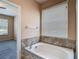 Relaxing bathroom includes a soaking tub with tiled accents and a window for natural lighting at 14137 Wake Robin Dr, Brooksville, FL 34604