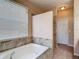 Bathroom featuring a soaking tub with tile surround, a window, and natural light at 14137 Wake Robin Dr, Brooksville, FL 34604