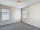 Bright bedroom features plush carpet, and natural light from two windows at 14137 Wake Robin Dr, Brooksville, FL 34604