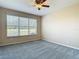 Comfortable bedroom with plush carpet, a ceiling fan, and a large window for natural light at 14137 Wake Robin Dr, Brooksville, FL 34604
