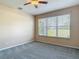 Bedroom with carpet flooring has a large window and a ceiling fan, offering comfort and charm at 14137 Wake Robin Dr, Brooksville, FL 34604