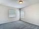Bedroom with neutral walls, carpeted floor, and natural light from two windows at 14137 Wake Robin Dr, Brooksville, FL 34604