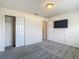Bedroom featuring plush gray carpet, a TV, and closet with sliding doors at 14137 Wake Robin Dr, Brooksville, FL 34604