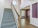 Bright entryway with carpeted stairs, wood banister, and adjacent room featuring wood-look flooring at 14137 Wake Robin Dr, Brooksville, FL 34604
