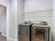 A modern laundry room features sleek, dark-colored appliances and wire shelving for ample storage at 14137 Wake Robin Dr, Brooksville, FL 34604