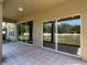 A covered patio featuring beige tile, columns, a ceiling light, and a view of the spacious back yard at 14137 Wake Robin Dr, Brooksville, FL 34604