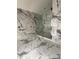 Modern bathroom featuring marble-style tile, frameless glass shower, and contemporary fixtures under construction at 14273 Nugent Circle, Spring Hill, FL 34609