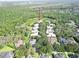 Expansive aerial view of the neighborhood showcasing lush greenery, serene pond, and beautifully landscaped home at 15101 Kestrelglen Way, Lithia, FL 33547