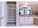 Bright bathroom featuring granite countertop, and sinks, and an open shelved linen closet at 15101 Kestrelglen Way, Lithia, FL 33547