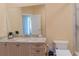 Bathroom vanity with granite countertop, large mirror, and neutral decor at 15101 Kestrelglen Way, Lithia, FL 33547