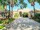 Stunning single-Gathering home featuring a beautiful tile roof, arched entryway, and lush landscaping, with a paved driveway at 15101 Kestrelglen Way, Lithia, FL 33547