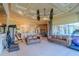 Open-concept living room with leather sofas, ceiling fan, and views of the kitchen and outdoor pool at 15101 Kestrelglen Way, Lithia, FL 33547