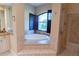 Main bathroom features a soaking tub with window, tiled shower, and granite countertops at 15101 Kestrelglen Way, Lithia, FL 33547