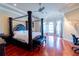 Spacious main bedroom featuring a four-poster bed, hardwood floors, and lots of natural light at 15101 Kestrelglen Way, Lithia, FL 33547
